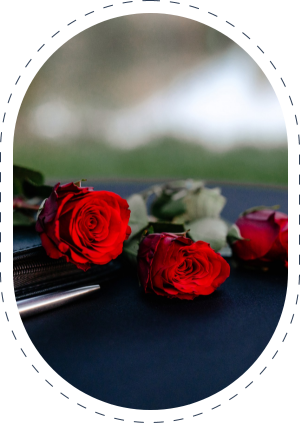 drei rote Rosen liegen auf einem schwarzen Tisch mit einem schwarzen Buch